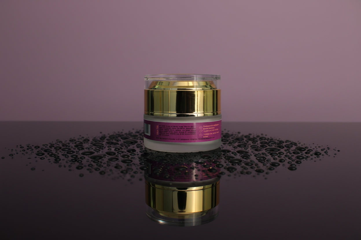 Skincare jar with gold lid and purple label on a reflective surface