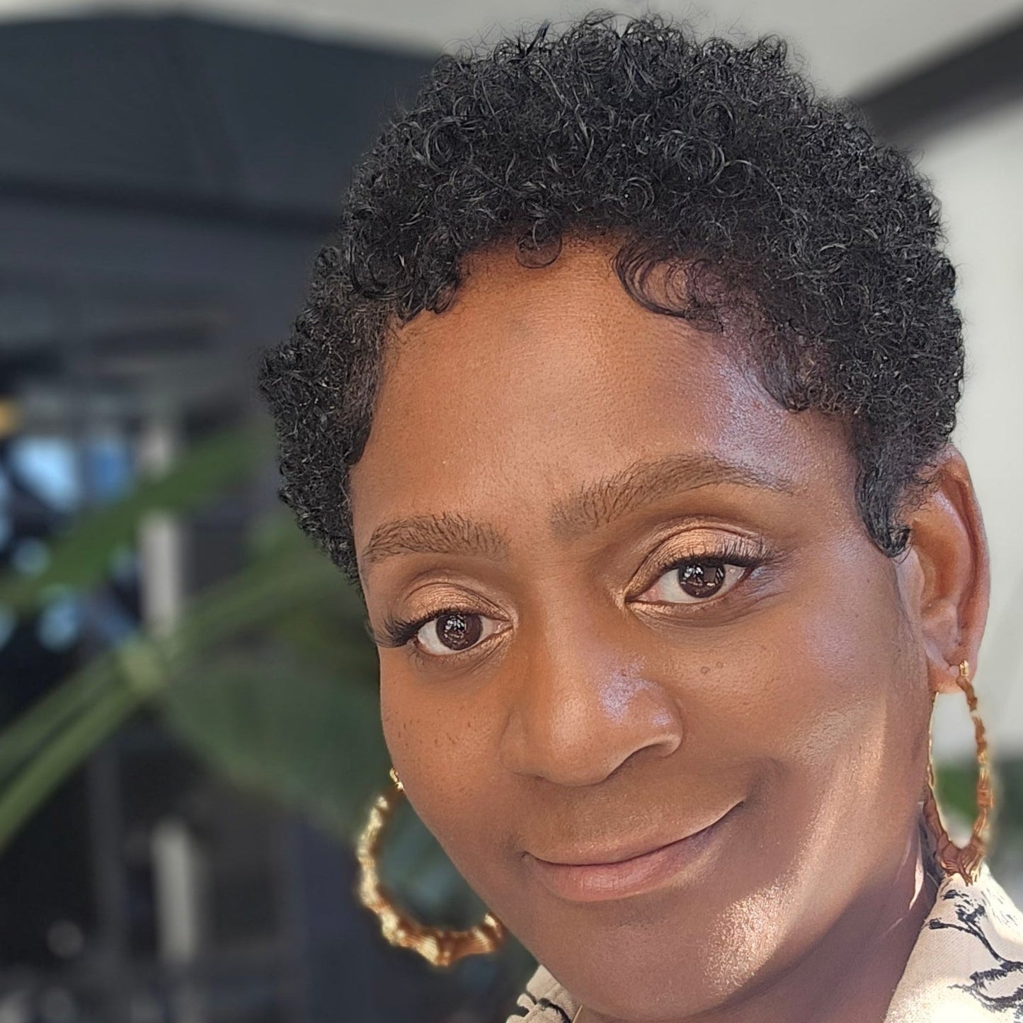 Person wearing a patterned shirt with a blurred background